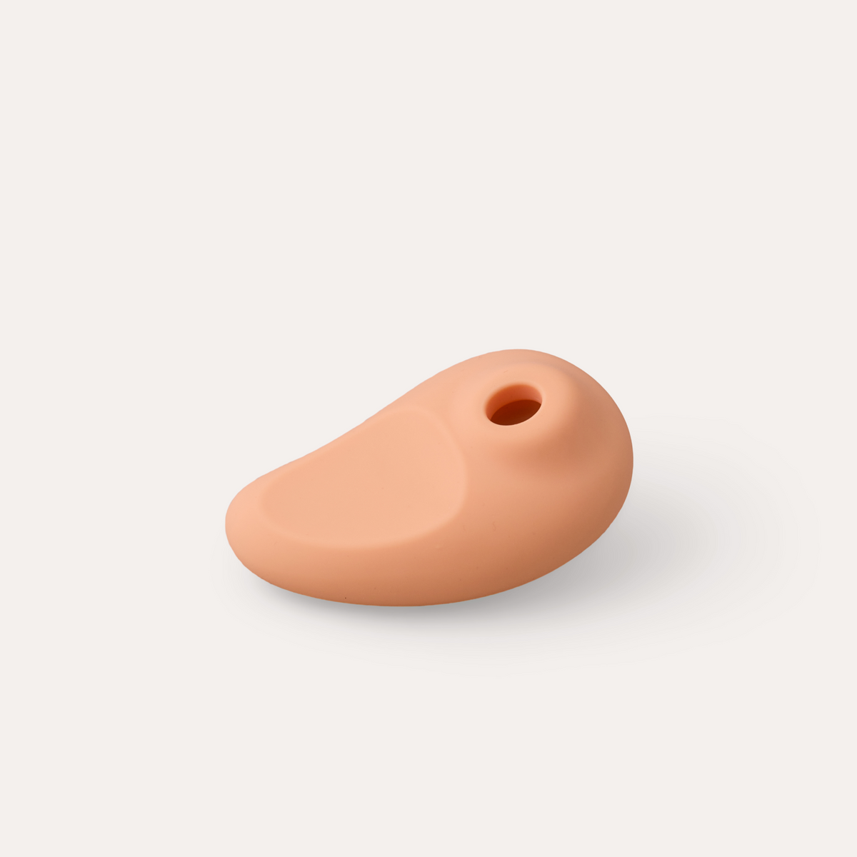The Draw lying flat, showing its curved thumb rest and suction opening